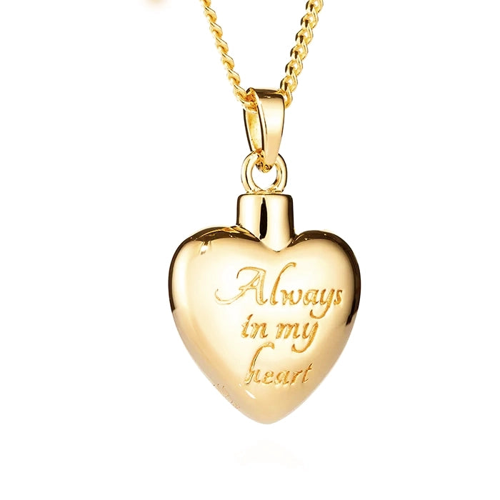 Gold heart-shaped cremation pendant with 'Always in my heart' engraving on the front on a white background