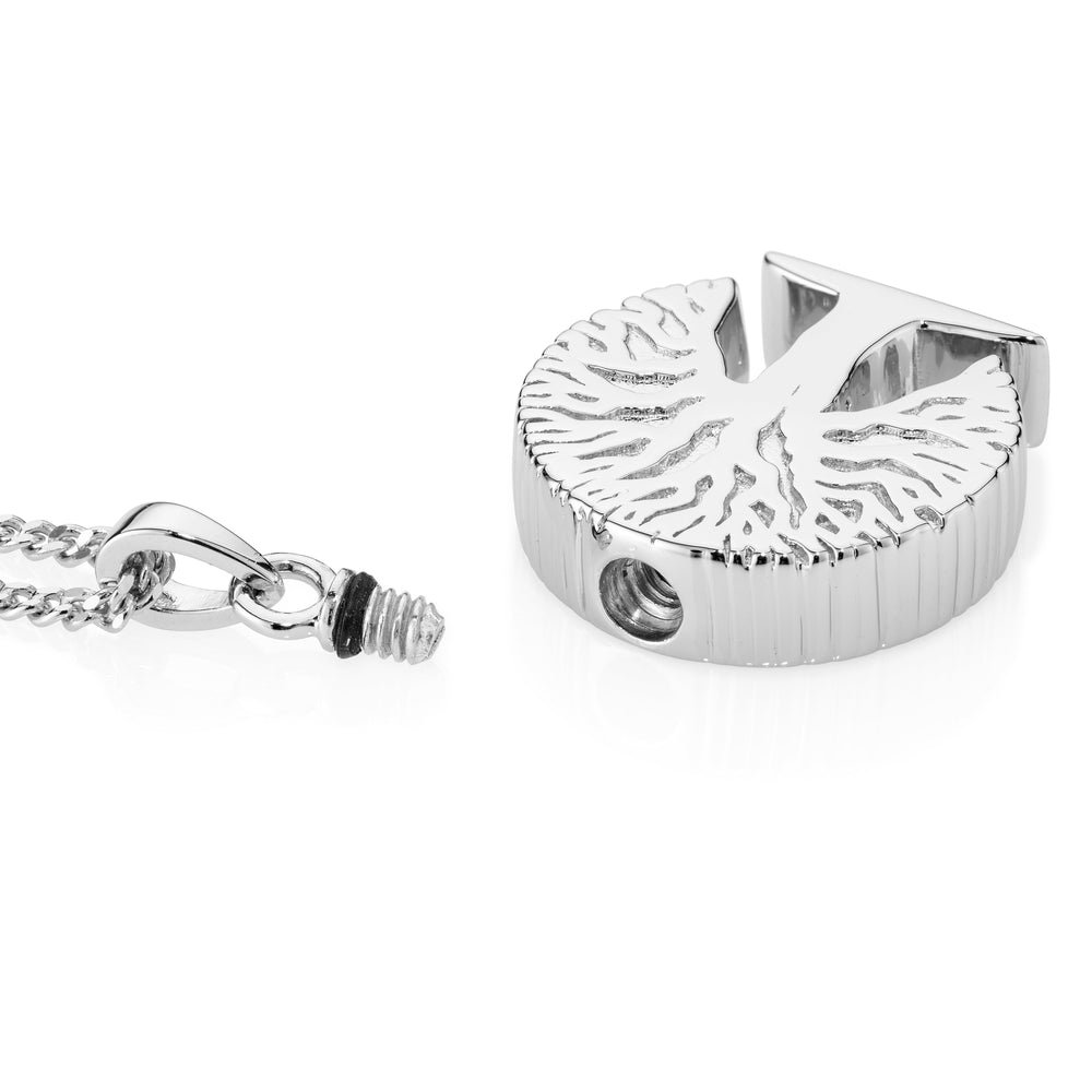 silver tree pendant lying on a white background