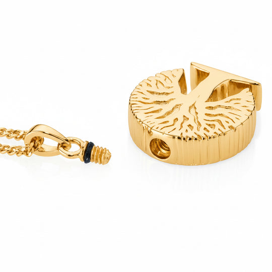 gold tree pendant lying on a white background