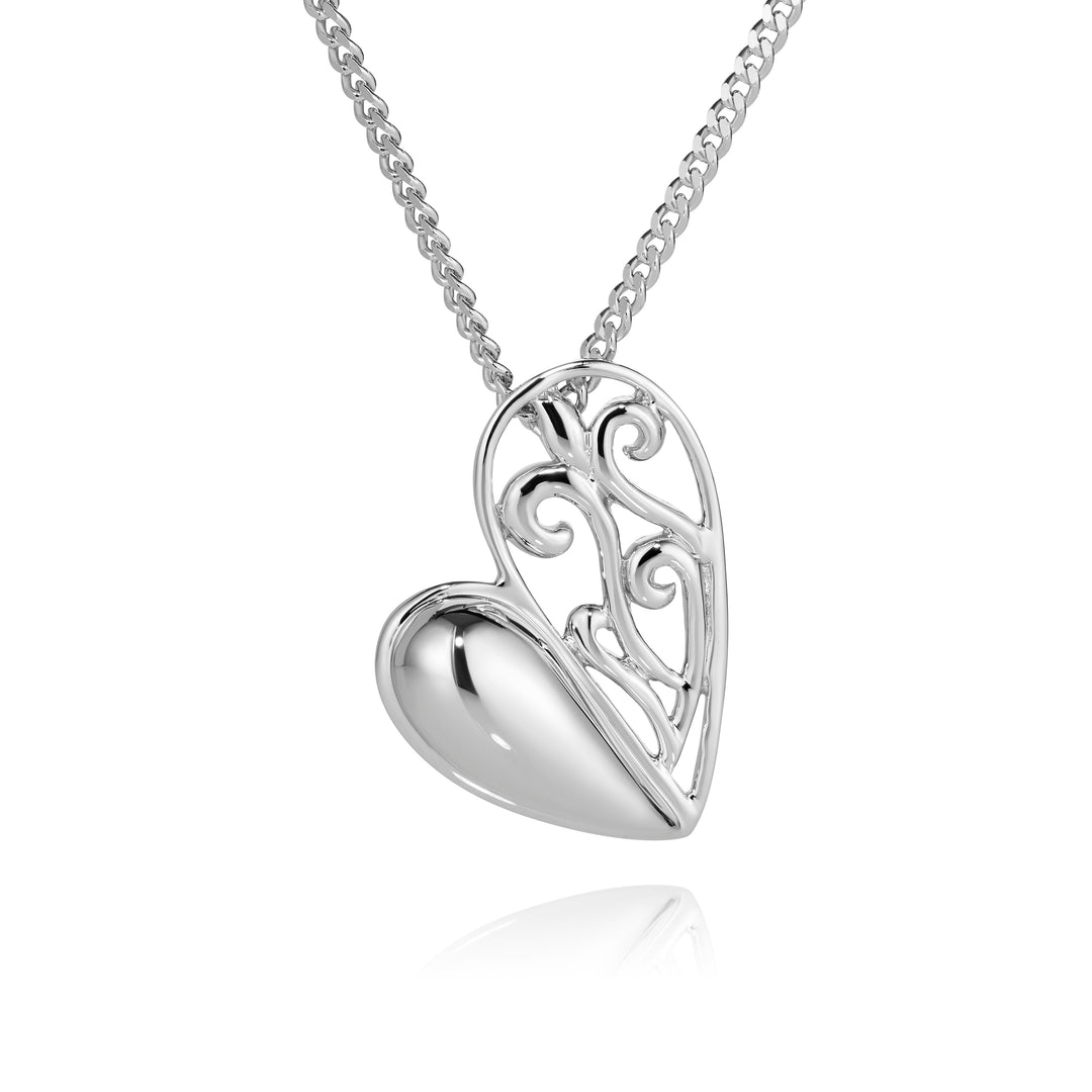 A silver heart pendant necklace with a polished, reflective heart shape and an openwork scroll design on a fine silver chain, shown against a white background with a soft reflection below.