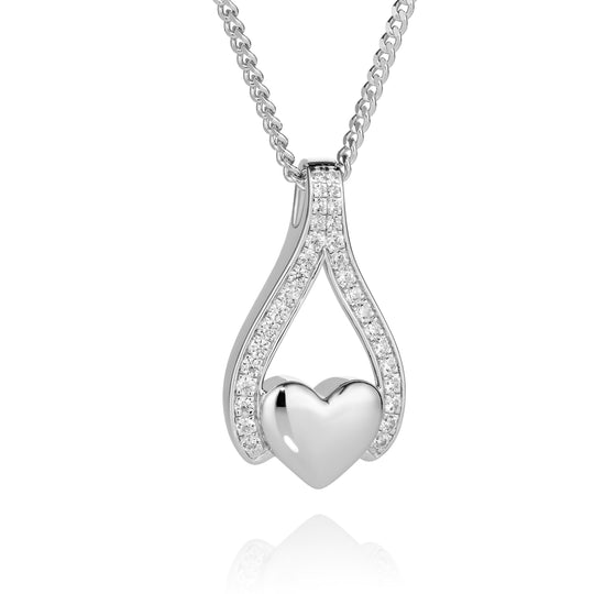 A silver heart pendant necklace with a polished heart in the center and pavé-set clear stones along the curved upper arms, hanging from a delicate silver chain against a white background.