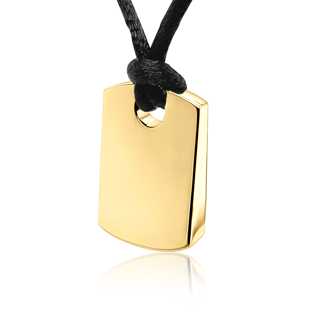 A polished gold dog tag pendant necklace with a black cord, shown against a clean white background with a subtle reflection below.
