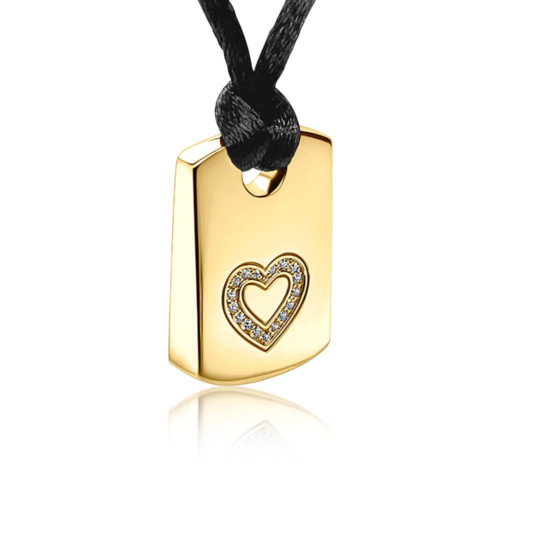 A gold rectangular pendant necklace with a small heart-shaped cutout outlined in sparkling clear stones, hanging from a black cord on a white background.
