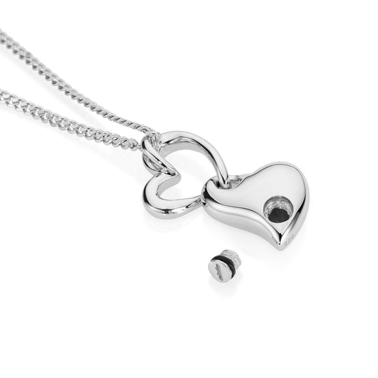 Silver heart-shaped pendant on a chain against a white background